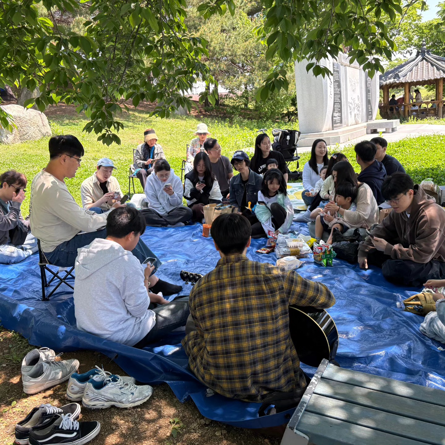 야외 잔디밭에 둘러앉아 이야기하는 나뭇가지교회 소그룹